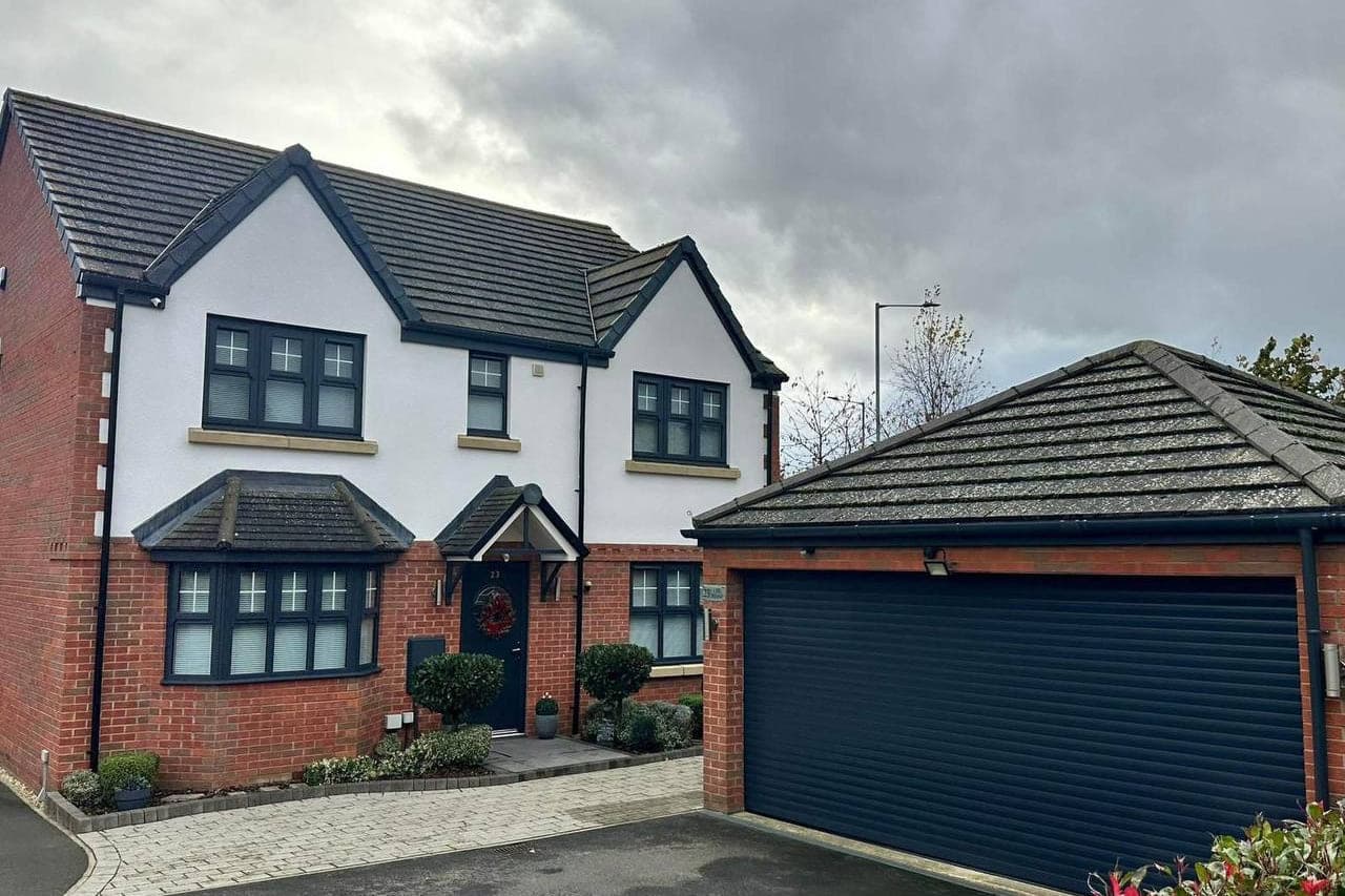 A full house elevation sprayed in anthracite grey: windows, front door, fascias, soffits and the garage door