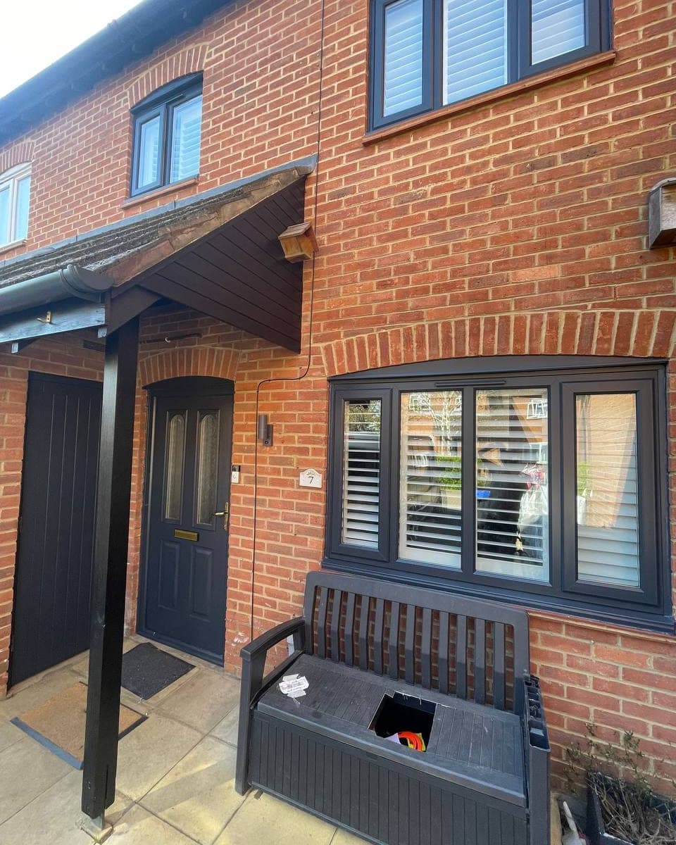 Windows, a front door and the porch timbers all sprayed the same anthracite grey