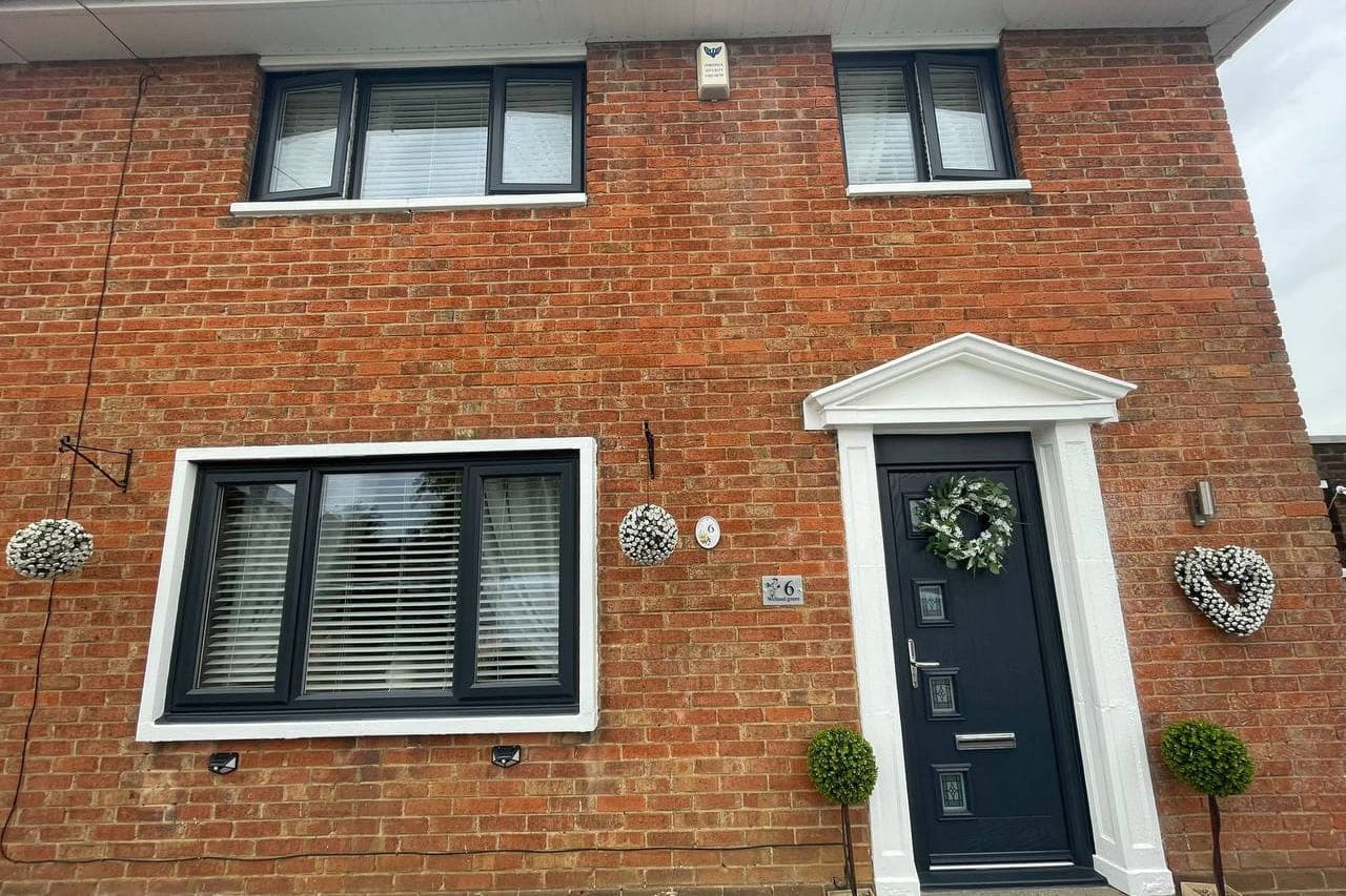 Anthracite sprayed windows and a front door set against a white painted surround