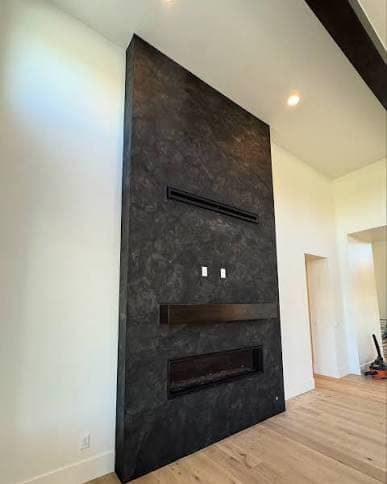 Polished plaster taken floor to ceiling across a chimney breast, in a charcoal finish