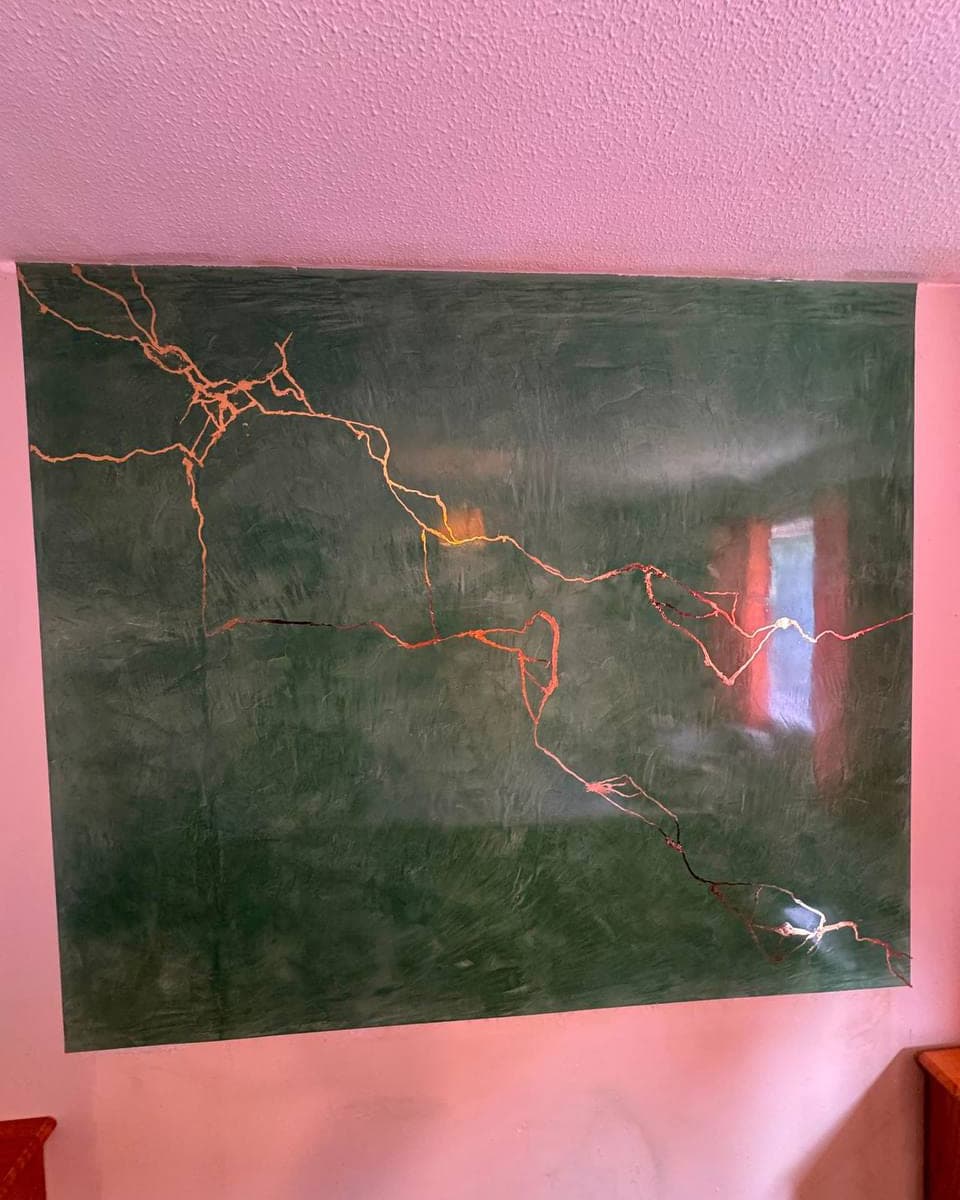 A polished plaster panel in deep green, with a metallic vein run through the finish